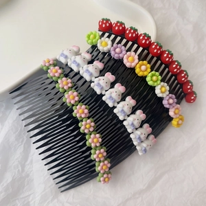Détail de peignes à cheveux pour enfants avec décorations de lapin, fraise et fleurs