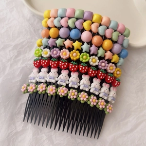 Macro shot of colorful resin cartoon charms and floral shapes on black plastic hair combs