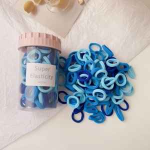 Blue elastic hair bands in transparent storage jar with decorative pink lid