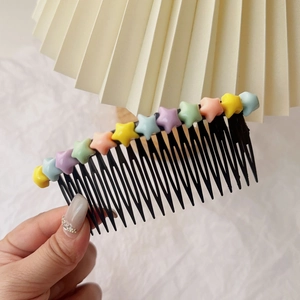 Détail d'un peigne à cheveux étoile coloré pour enfants avec finition en résine mate