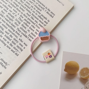 Élastique à cheveux rose avec breloque cupcake 3D et étiquette florale sur livre