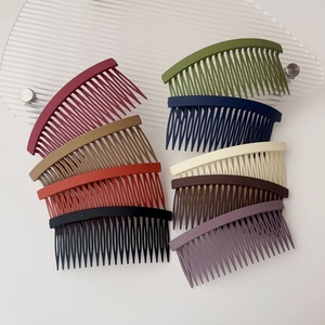 Set of colorful matte hair side combs in nine vibrant shades on a textured glass tray