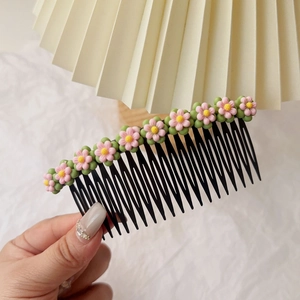 Détail d'un peigne à cheveux floral avec dix fleurs roses et dents noires pour filles