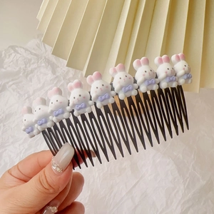 Détail d'un peigne à cheveux pour fille avec neuf mignons lapins en résine 3D roses