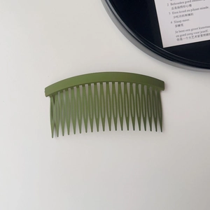 Macro detail of olive green matte hair finishing comb with smooth curved teeth design