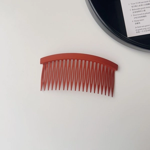 Detail of 20-tooth matte brick red hair comb with non-slip curved resin design