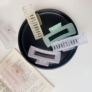 Matte rectangle claw clips in pastel colors on a black tray with book decor
