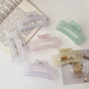 Close-up of six matte large rectangular hair claw clips in assorted pastel candy colors