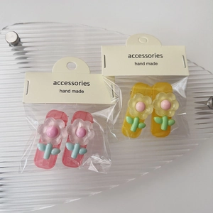 Dettaglio di fermagli per capelli fatti a mano con fiori in resina rosa e gialli