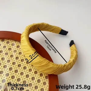 Detail view of yellow pleated fabric headband with dimensions and weight parameters