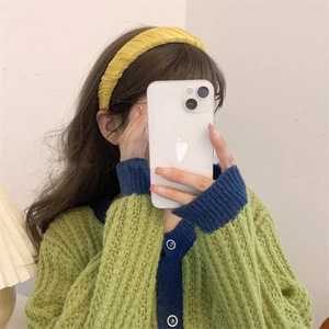 Close-up of a bright yellow pleated satin headband creating a high cranial top hair look