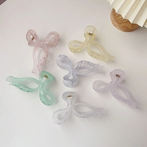 Bow-shaped jelly hair claws in pastel colors including pink, yellow, and blue