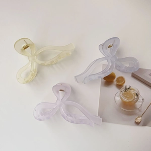 Three large matte jelly-colored butterfly hair claws in pastel yellow, blue, and purple