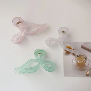 Three large jelly-colored bow hair claws in pink, mint green and translucent white colors
