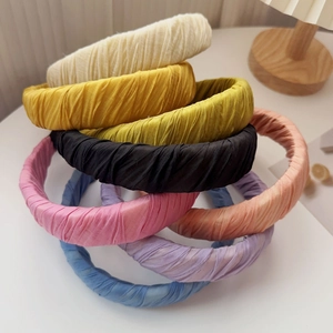 Detail of pleated fabric headbands in various candy colors showing texture and volume
