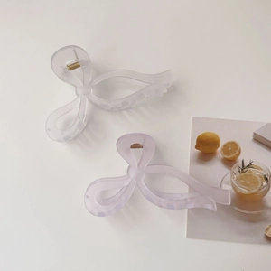 Close-up of jelly color bow hair claws in translucent white and light purple colors