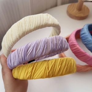 Detail showing colorful pleated fabric texture on wide headbands in candy macaron tones