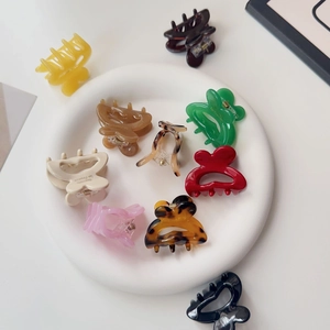 Detailed view of ten colorful acrylic butterfly hair claws in various finishes and patterns