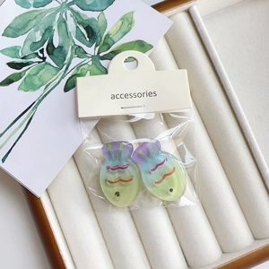 Detail of colorful gradient fish-shaped hair clips in professional jewelry box packaging