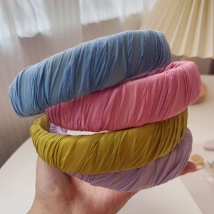 Close-up of ruched wide headbands in pastel candy colors with soft pleated fabric texture