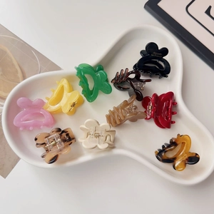 Detail of assorted mini claw clips on white tray featuring Barrette la France text