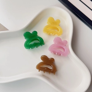 Set of four colorful butterfly hair claws in pastel tones on a white tray