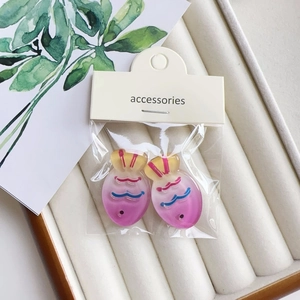 Close-up of resin gradient fish hair clips with colorful patterns and accessory tag