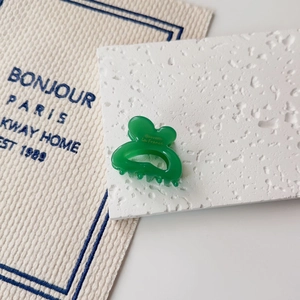 Close-up of a translucent green hair claw clip with yellow la France text decoration