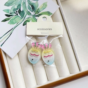 Close-up of colorful gradient fish resin hair clips in branded packaging on a display