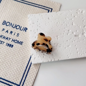 Detailed macro view of a vintage tortoiseshell resin hair claw clip on beige fabric