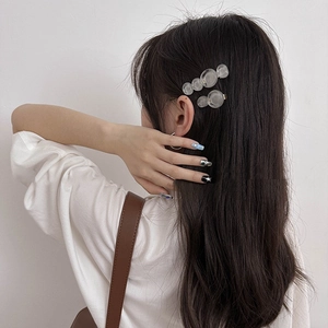 Set of two translucent white bubble hair clips on long hair with a minimalist design