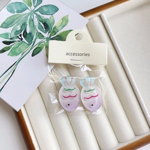 Detail of colorful gradient fish hair clips in clear OPP packaging on a jewelry tray
