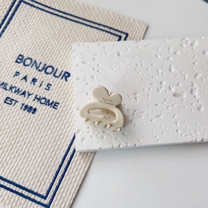 Detail of cream mini hair claw clip featuring Barrette La France text in French style