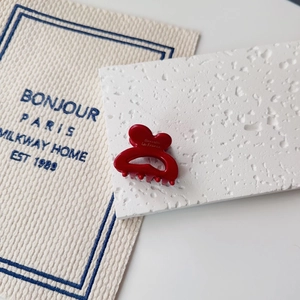 Detail of red French barrette with Barrette la France text on textured stone