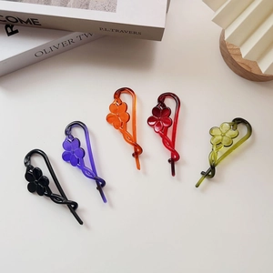 Five colorful macaron flower banana hair clips set on aesthetic book background