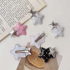 Detail of glitter Y2K star hair clips in pink and black with metal duckbill backings