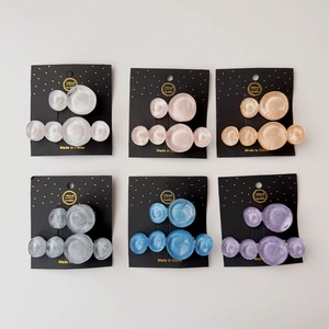 Detail of colorful resin wave pattern hair clips set on cardboards in multiple shades
