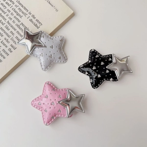 Detail view of colorful Y2K star hair clips in black, white, and pink with sequin accents