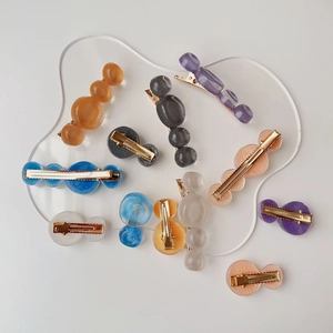 Detailed close-up of water ripple resin hair clips with elegant gold metal bases