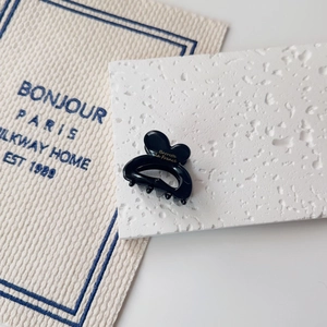 Detail of a black resin heart hair claw with gold Barrette La France text and metal spring