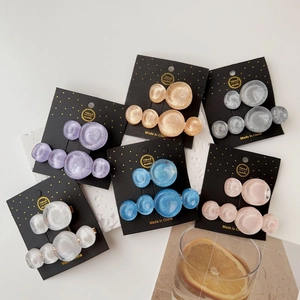 Close-up of marble texture resin hair clips in various colors with geometric round shapes