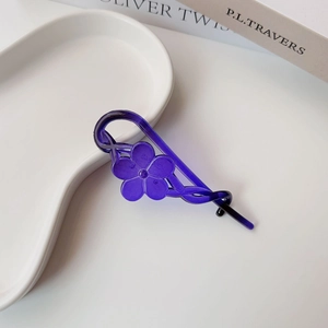 Close-up of a purple floral banana hair clip with a five-petal resin flower and matte finish