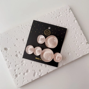 Detail of pink resin hair clips with ripple texture on white stone decorative stand