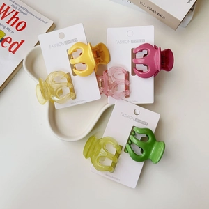 Detailed view of colorful jelly-tone mini pumpkin hair claws on retail card packaging