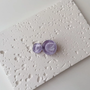 Detailed macro of purple circular resin hair clips with elegant spiral ripple texture