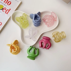 Detail of candy-colored pumpkin hair claws arranged on a white ceramic plate