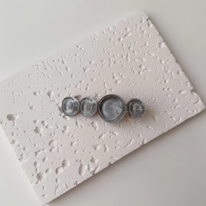 Detail of grey resin marble pattern circles on a golden metal hair clip for women