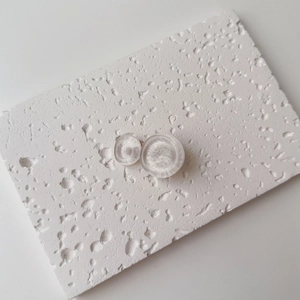 Detailed view of semi-transparent water ripple resin circles on a textured white stone