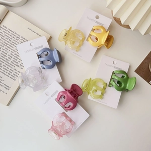 Assorted colorful jelly pumpkin hair claws on display cards with aesthetic props
