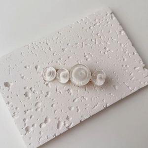 Detail of elegant water ripple resin hair clip with four translucent white circular patterns